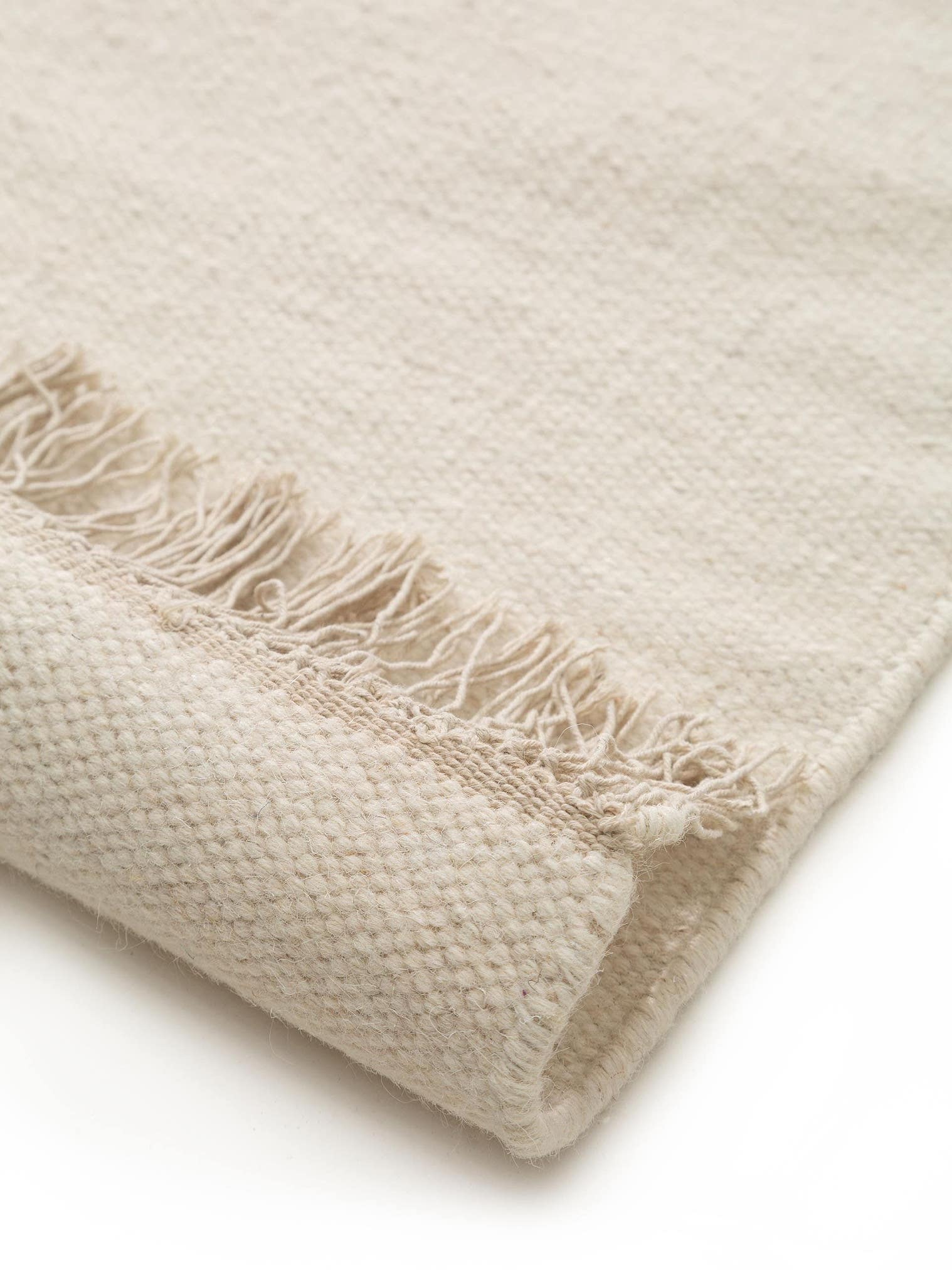 Teppich aus 90% Wolle, 10% Baumwolle in Weiß mit bis 5 mm hohem Flor von benuta Pure