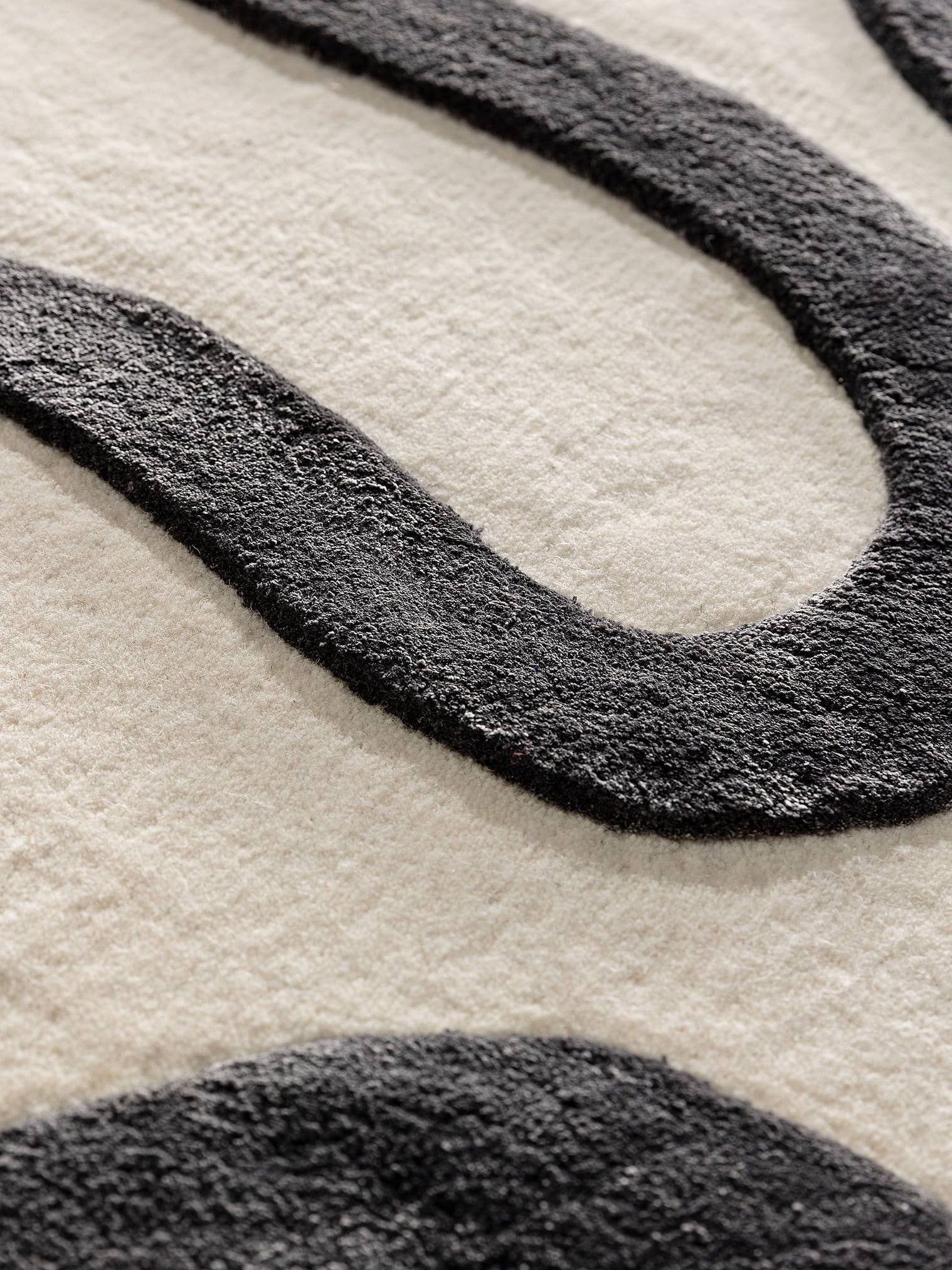 Teppich aus 75% Wolle, 25% Lyocell (TENCEL™) in Schwarz/Weiß mit 6 bis 10 mm hohem Flor von benuta Finest